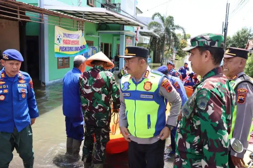 Personel Polresta Pati bersama Forkopimcam Juwana mendistribusikan bantuan logistik menggunakan perahu ke desa-desa terdampak banjir di Kecamatan Juwana, Kabupaten Pati, Senin (19/1/2026).
